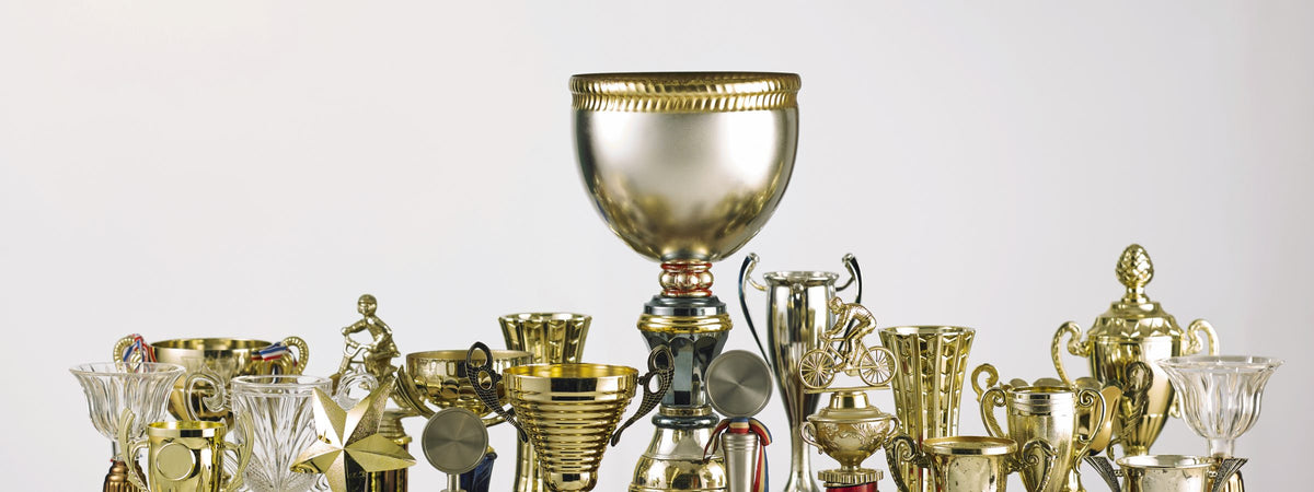 Copas y trofeos dorados sobre fondo blanco